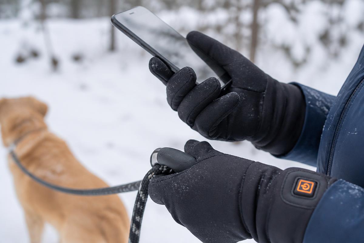 Handy und Hundeleine mit dünnen Heizhandschuhen bedienen